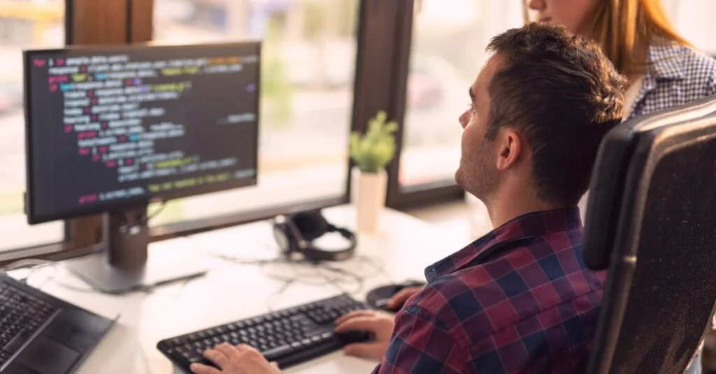 Человек кодит за компьютером
